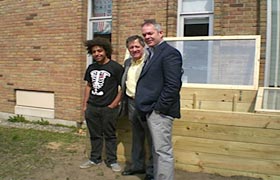 Senior Ramell Collins is pictured with Principal Dale Hovenkamp and Palmer outdoors near the cold box he built to use sunlight to raise plants in the winter.